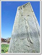 高さ約2メートルもある石碑に阿弥陀如来立像の浮き彫りがされた文永弥陀浮彫大板碑の写真