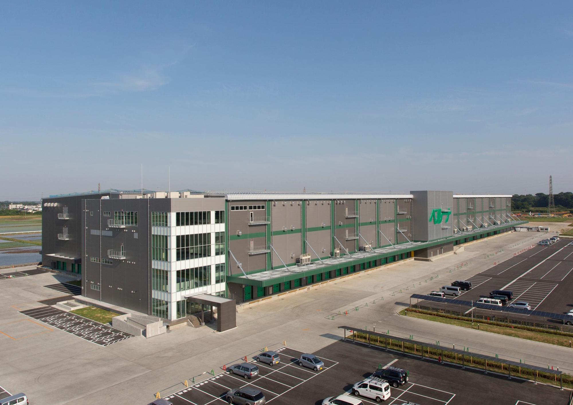 広い敷地に広い駐車場、大きな建物が建つ株式会社ベルーナのオフィスの外観の写真